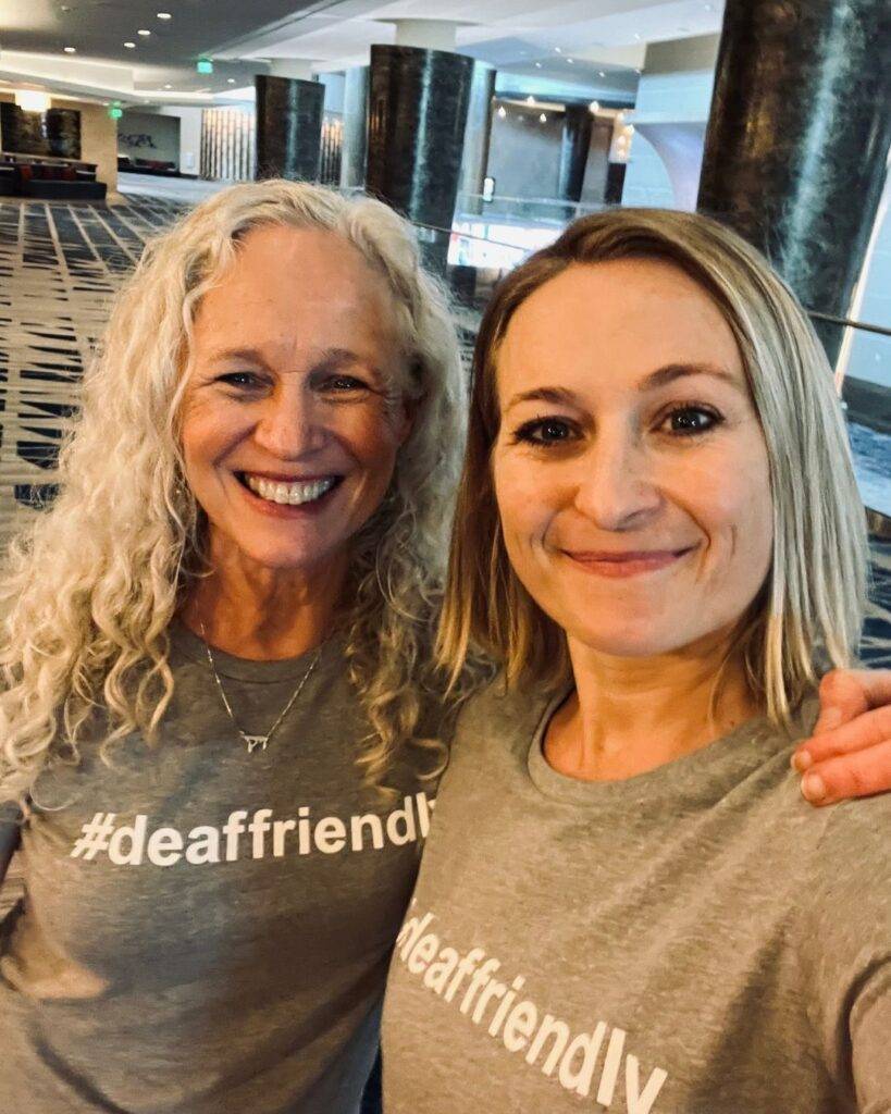 two white women took a selfie together with their grey #deaffriendly t-shirt