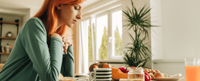 Dinner Table Syndrome. A woman is looking quiet and sad at the dinner table.