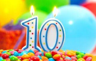 a photo of "10" birthday candles on candies and balloons in the background