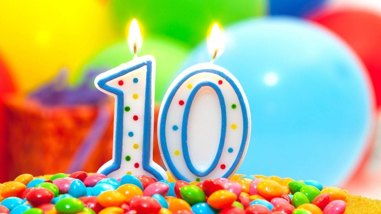 a photo of "10" birthday candles on candies and balloons in the background
